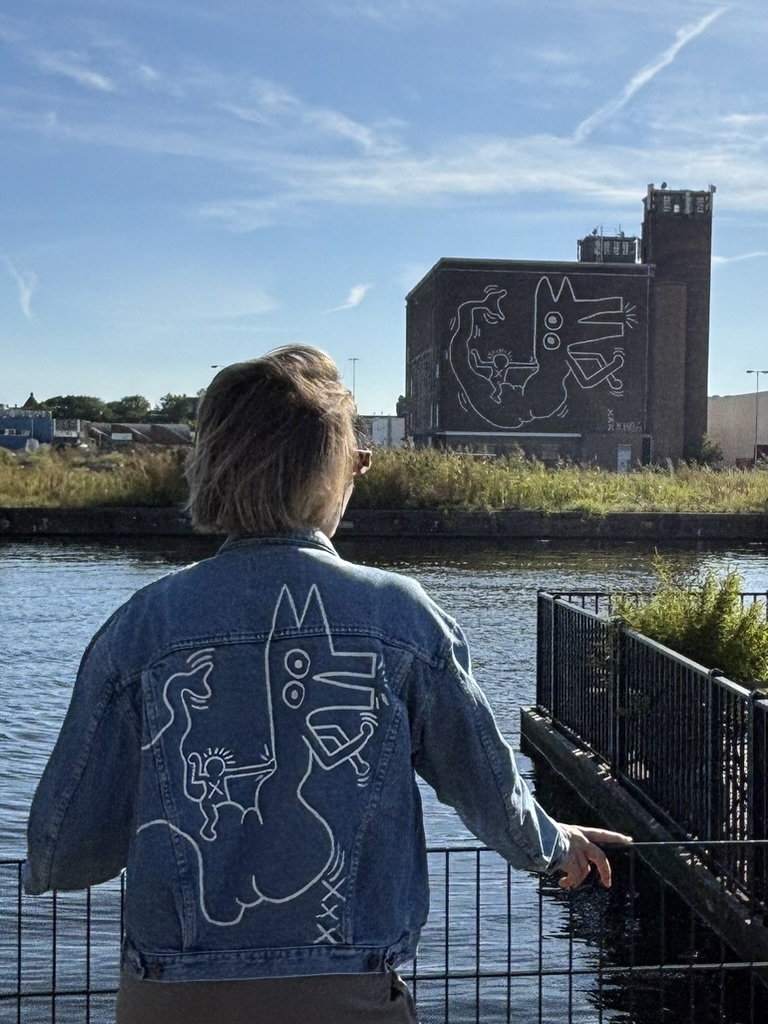 Marijn in een beschilderde spijkerjas bij de Haring-schildering op de Centrale Markthallen
